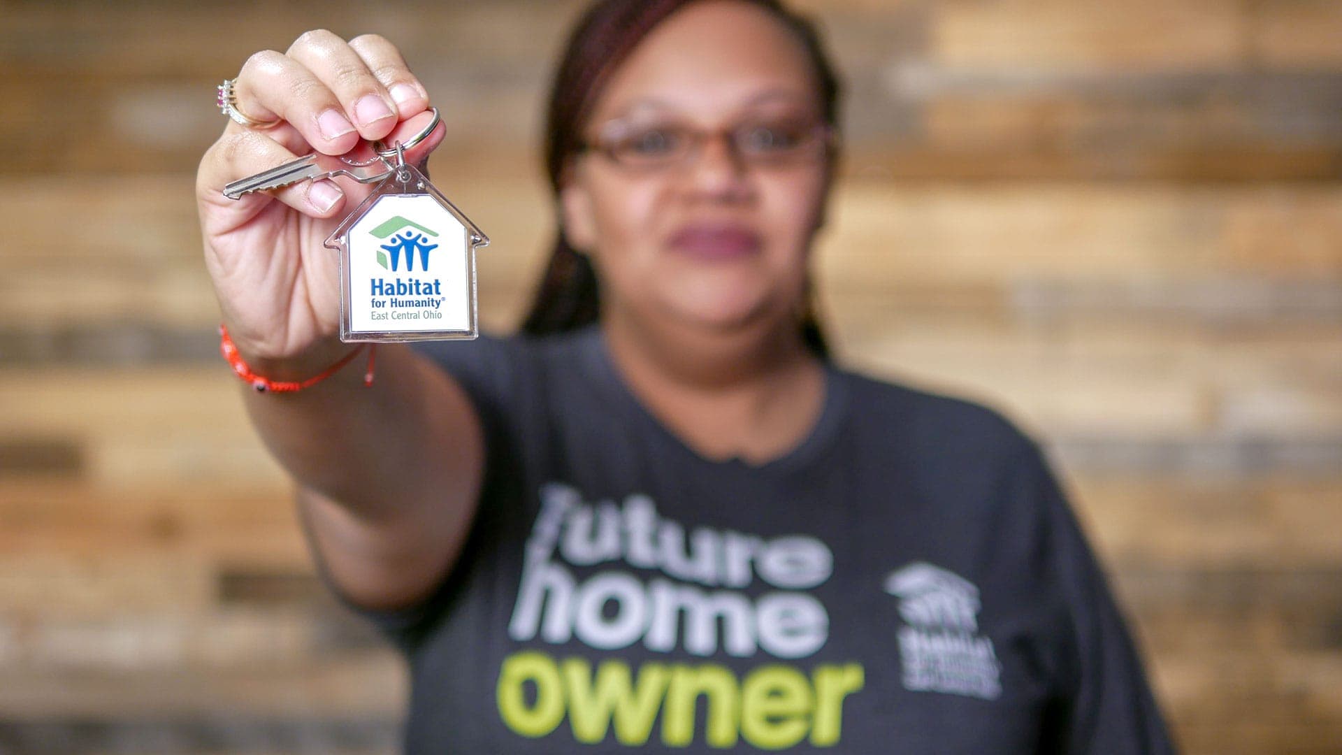 Habitat for Humanity homeowner holding keys to home.